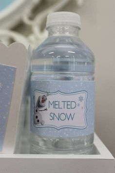 a bottle of water sitting on top of a white shelf next to a card board