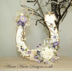 a white and purple flowered wreath on top of a wooden table