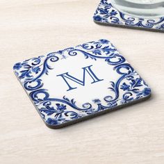 a blue and white square coaster with the letter m on it's center piece