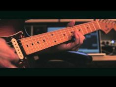 a person playing an electric guitar in a recording studio