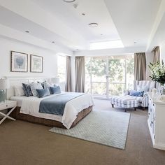 a bedroom with a large bed sitting next to a white dresser and chair in front of a sliding glass door