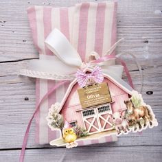 a pink and white barn shaped gift bag