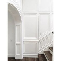 an image of a white room with wood flooring and wall paneling on the walls