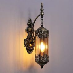 an old fashioned wall light hanging on the side of a wall