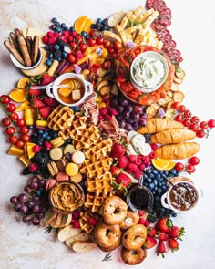 an assortment of food is arranged in the shape of a heart on a white surface