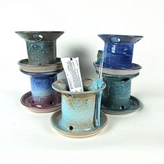 three blue and purple vases sitting on top of each other