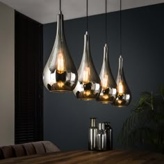 five lights hanging over a wooden table in a room