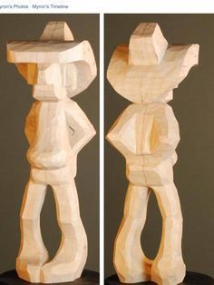 two wooden sculptures sitting side by side on top of a table next to each other