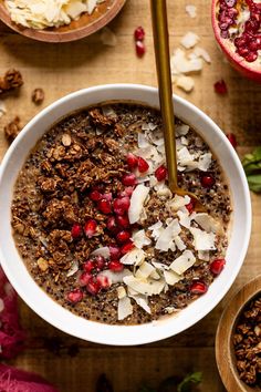 a bowl filled with granola and topped with pomegranate