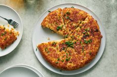 a cheese pizza on a white plate with a slice missing from it and two plates next to it