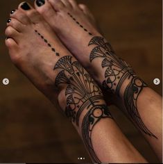 two people with tattoos on their arms and feet, both holding each other's hands