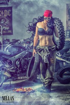 a woman standing in front of a motorcycle