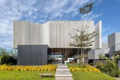 the house is made up of concrete blocks and has a garden in front of it