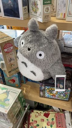 a stuffed animal sitting on top of a wooden shelf in a store filled with books