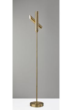 a gold floor lamp with two lights on each side and one light on the other