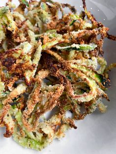 some fried food on a white plate with broccoli florets in it