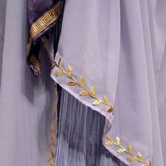 a close up of a person's dress with gold trimmings on it