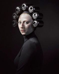 a woman with hair rollers on her head in front of a black background,