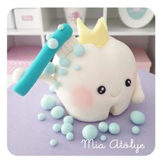 a close up of a cake with an elephant on it's head and a toothbrush in its mouth