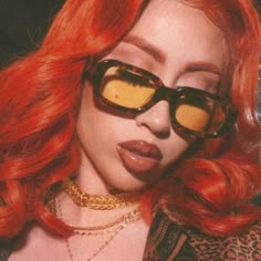 a woman with red hair wearing sunglasses and leopard print shirt