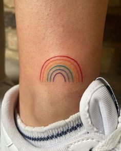 a small rainbow tattoo on the ankle