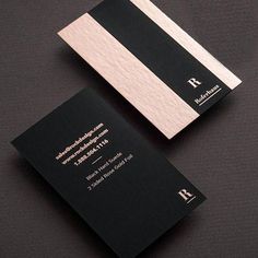 two black and white business cards sitting on top of each other