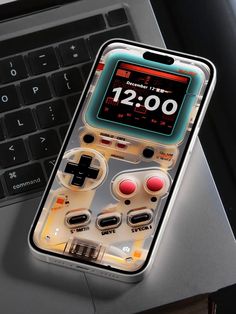 an iphone case that has a game controller on it, sitting next to a laptop