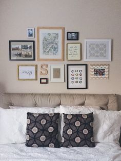 a bed with pillows and pictures on the wall