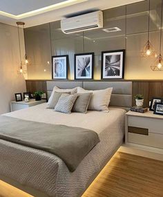 a bedroom with a bed, nightstands and pictures hanging on the wall above it