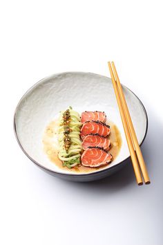 a white plate topped with sushi and chopsticks