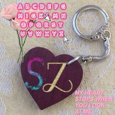 a heart shaped keychain with the letter j on it and a pink rose