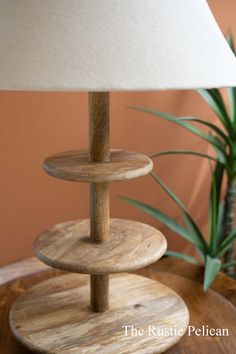 a wooden table with a lamp on top of it next to a potted plant