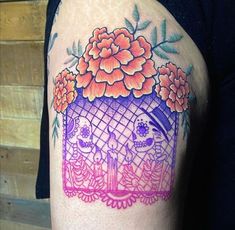 a woman's arm with an image of flowers and two cats on the inside of it