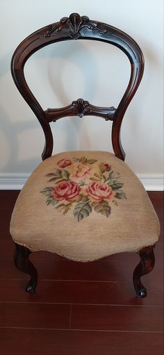 an antique chair with a floral design on the back