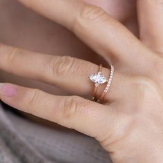 a woman's hand with a diamond ring on her left and an engagement band on her right