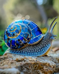 a blue snail sitting on top of a rock