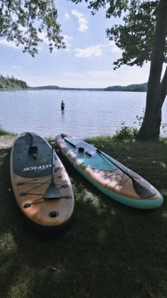 two kayaks sitting on the grass near water