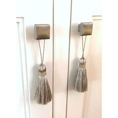 two metal door handles with tassels on them