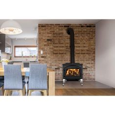 a wood burning stove sitting in the middle of a kitchen next to a dining room table