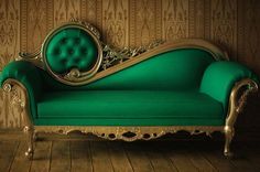 a green couch sitting on top of a wooden floor