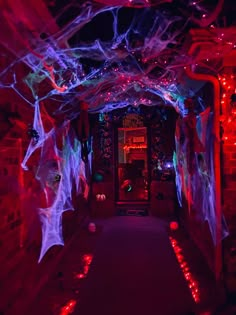 the hallway is decorated with halloween decorations and spider webs, all lit up at night