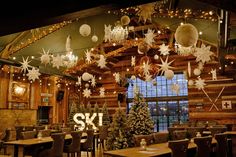 an indoor restaurant decorated for christmas with lights and snowflakes hanging from the ceiling