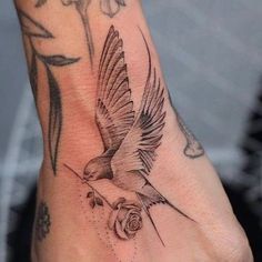 a hand with a bird tattoo on it