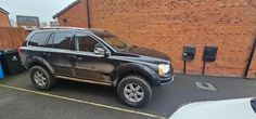 an suv parked in front of a brick building