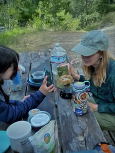 two women sitting at a picnic table with food