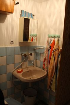 a bathroom with a sink, mirror and towels on the rack next to the toilet