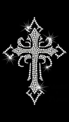 a cross made up of white pearls on a black background with stars in the middle