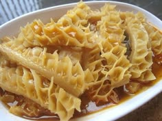 a white bowl filled with pasta and sauce