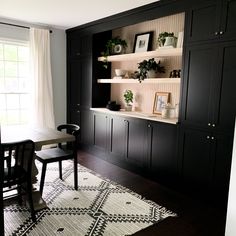 a dining room with black cabinetry and white rug on the floor next to it