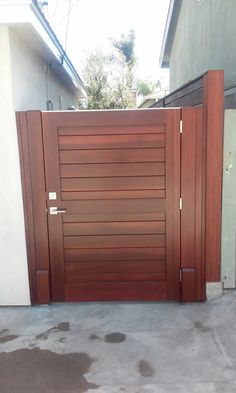 a large wooden gate in front of a house with two doors on each side and one door open